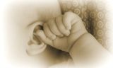 Eine Babyhand, die das Ohr eines Babys hÃ¤lt
