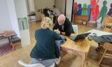 Eine Person und eine Person, die an einem Tisch mit einem Laptop sitzt
