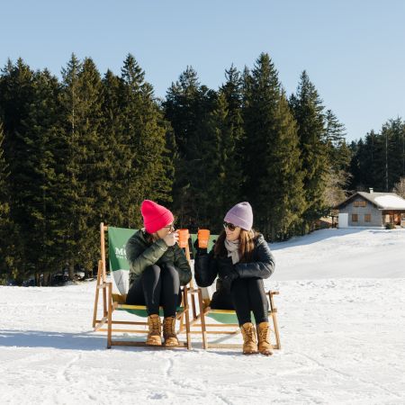 Getränk im Liegestuhl im Schnee in der Sonne Getränk im Liegestuhl im Schnee in der Sonne