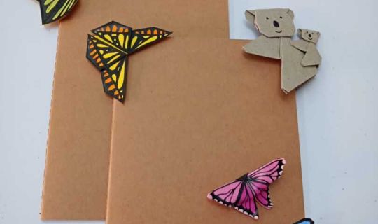 Ein brauner Umschlag mit Papierschmetterlingen und einem Bären Ein brauner Umschlag mit Papierschmetterlingen und einem Bären