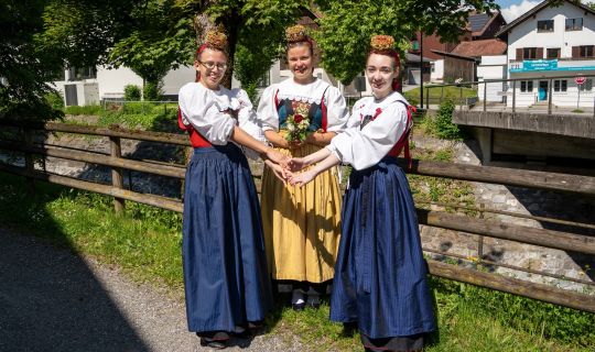 Eine Gruppe von Frauen in Kleidern und Händchen haltend Eine Gruppe von Frauen in Kleidern und Händchen haltend