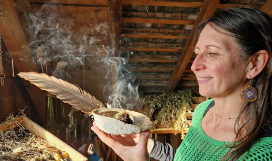 Kräuterpädagogin Jasmin Vigl verteilt den Rauch aus der Räucherschale mit einer Feder. Kräuterpädagogin Jasmin Vigl verteilt den Rauch aus der Räucherschale mit einer Feder.