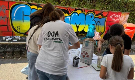 Eine Gruppe von Menschen, die um einen Tisch mit Graffiti bedeckten Tisch steht Eine Gruppe von Menschen, die um einen Tisch mit Graffiti bedeckten Tisch steht