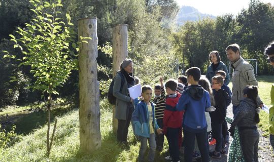 Eine Gruppe von Menschen, die um einen Baum stehen Eine Gruppe von Menschen, die um einen Baum stehen