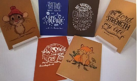 Eine Gruppe von Notizbüchern mit unterschiedlichen Designs Eine Gruppe von Notizbüchern mit unterschiedlichen Designs