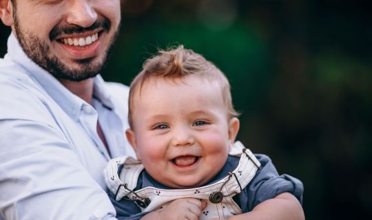 Eine Person, die ein Baby hÃ¤lt.