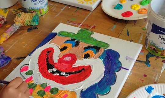 Eine Gruppe von Kindern, die auf einem Tisch malt Eine Gruppe von Kindern, die auf einem Tisch malt