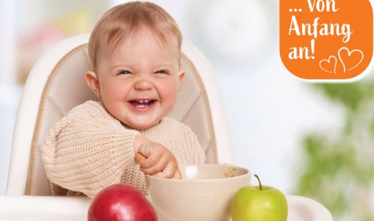 Ein Baby, das in einem Hochstuhl mit einer SchÃ¼ssel Futter sitzt