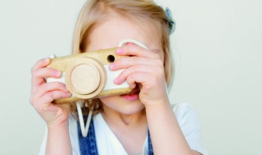 Ein Kind macht ein Foto mit einer Spielzeugkamera. Ein Kind macht ein Foto mit einer Spielzeugkamera.