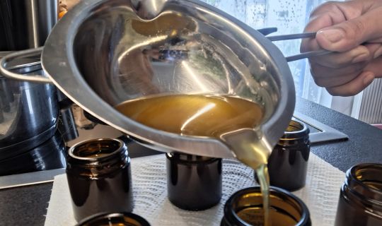 Eine Person, die Flüssigkeit in kleine Gläser gieÃt Eine Person, die Flüssigkeit in kleine Gläser gieÃt