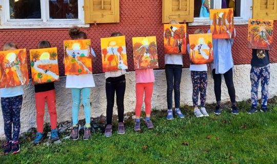 Eine Gruppe von Kindern, die Gemälde hochhalten Eine Gruppe von Kindern, die Gemälde hochhalten