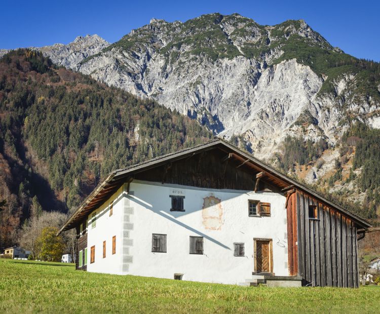 Montafoner Bauernhaus vor Vandanser Steinwand Montafoner Bauernhaus vor Vandanser Steinwand