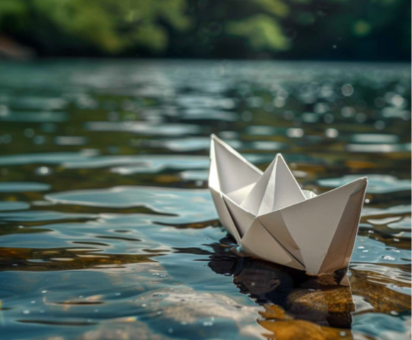 ein Papierboot, das auf dem Wasser treibt