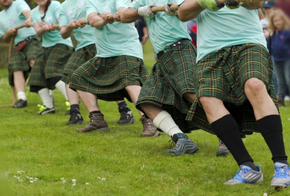Eine Gruppe MÃ¤nner in Kilts, die an einem Seil ziehen