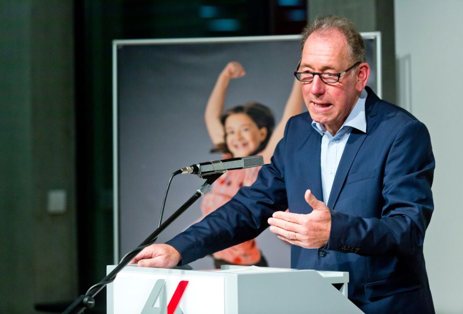 Eine Person, die mit einem Mikrofon an einem Podium steht