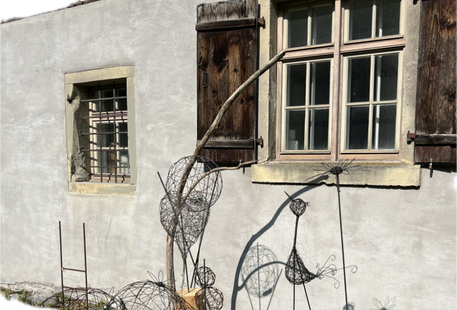 Ein Fenster mit Zaun und Drahtskulptur Ein Fenster mit Zaun und Drahtskulptur