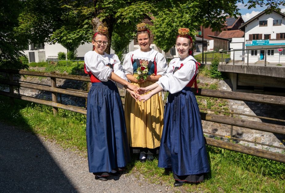 Eine Gruppe von Frauen in Kleidern und Händchen haltend Eine Gruppe von Frauen in Kleidern und Händchen haltend