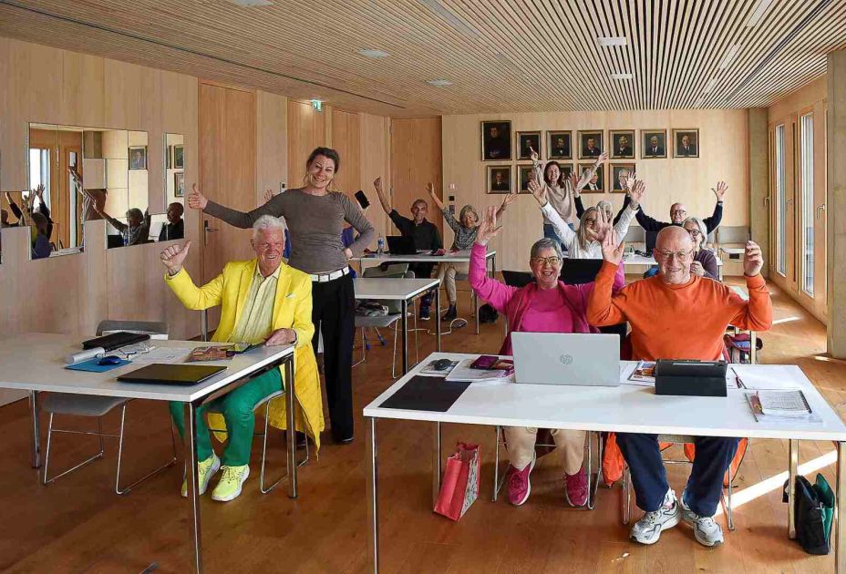 Eine Gruppe von Menschen in einem Raum mit erhobenen Händen Eine Gruppe von Menschen in einem Raum mit erhobenen Händen