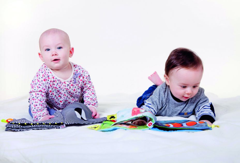 Babys, die nebeneinander auf dem Boden liegen