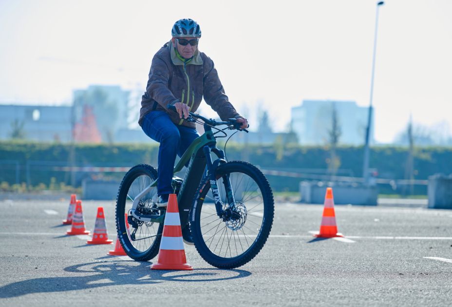Eine Person, die mit einem Fahrrad auf einer StraÃe mit orangefarbenen Kegeln fÃ¤hrt