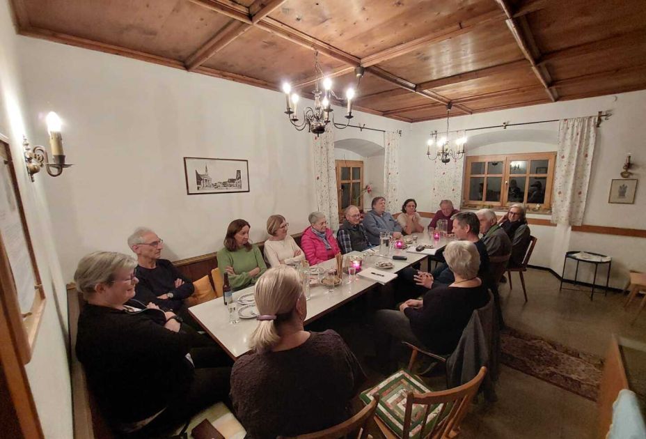 Eine Gruppe von Menschen, die um einen Tisch sitzen Eine Gruppe von Menschen, die um einen Tisch sitzen