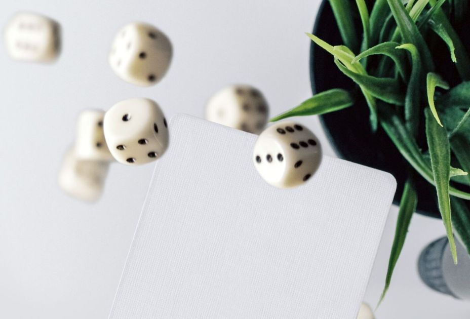WÃ¼rfel, die auf eine Karte fallen, mit einer Pflanze im Hintergrund