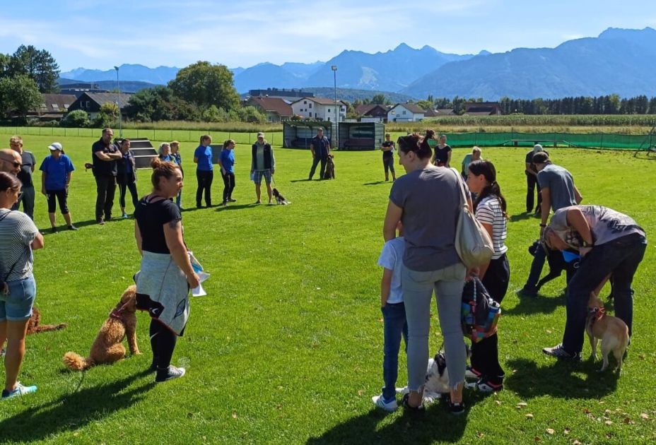 Eine Gruppe von Menschen auf einem Feld mit einem Hund