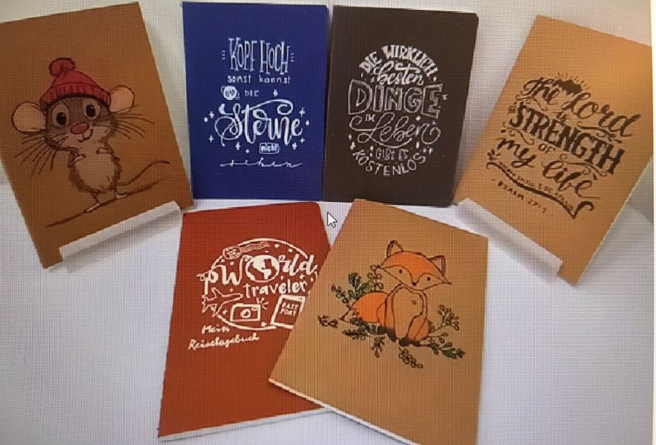 Eine Gruppe von Notizbüchern mit unterschiedlichen Designs Eine Gruppe von Notizbüchern mit unterschiedlichen Designs