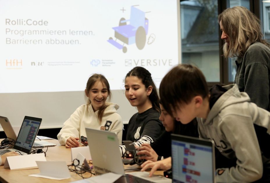 Eine Gruppe von Menschen, die mit Laptops um einen Tisch sitzen Eine Gruppe von Menschen, die mit Laptops um einen Tisch sitzen