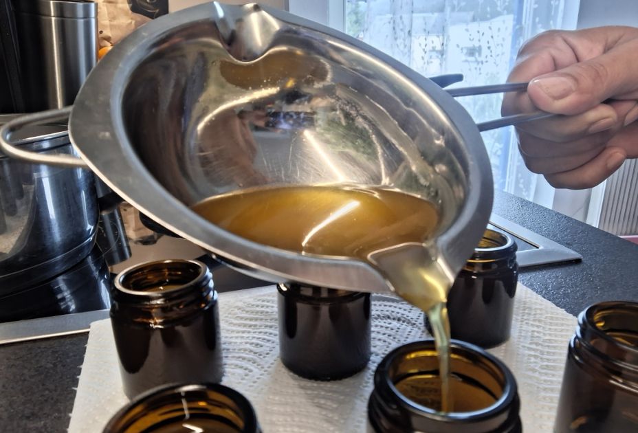 Eine Person, die Flüssigkeit in kleine Gläser gieÃt Eine Person, die Flüssigkeit in kleine Gläser gieÃt