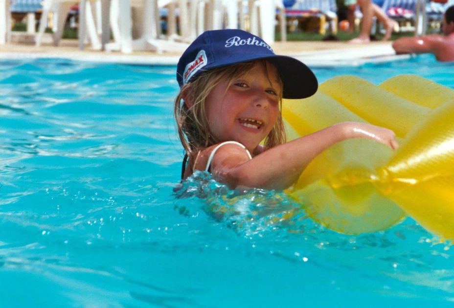 Ein Kind schwimmt in einem Pool mit einer Luftmatratze. Ein Kind schwimmt in einem Pool mit einer Luftmatratze.