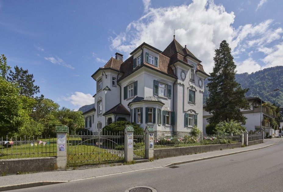 Ein Haus mit Zaun und Gras Ein Haus mit Zaun und Gras