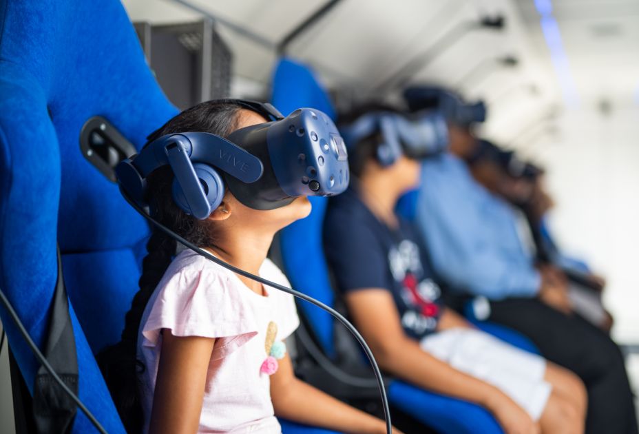 Ein Kind, das ein Virtual-Reality-Headset trÃ¤gt und in einem Flugzeug sitzt
