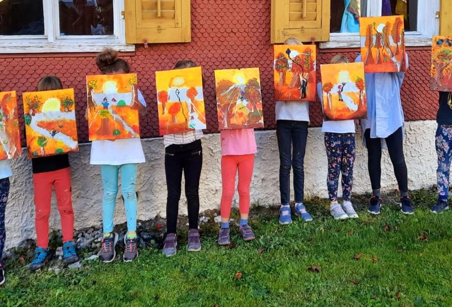 Eine Gruppe von Kindern, die Gemälde hochhalten Eine Gruppe von Kindern, die Gemälde hochhalten